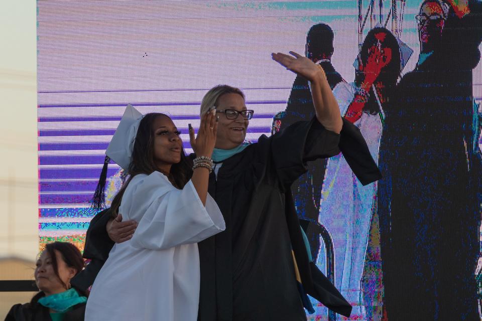 A Victor Valley High School graduate waves with principal Nancy Noyer during a ceremony in Victorville on Tuesday.