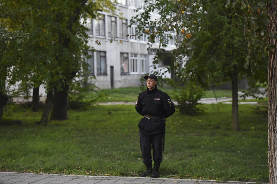 A policeman stands guard near a vocational college in Kerch, Crimea, Thursday, Oct. 18, 2018. An 18-year-old student strode into his vocational school in Crimea, a hoodie covering his blond hair, then pulled out a shotgun and opened fire on Wednesday, killing scores of students and wounding dozens of others before killing himself. (AP Photo/Sergei Demidov)