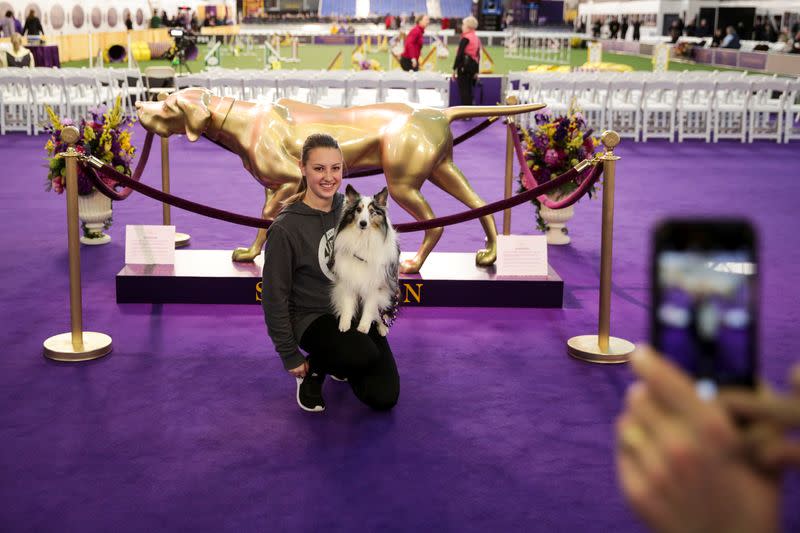 A woman poses for a picture with her dog ahead of the Masters Agility Championship during the Westminster Kennel Club Dog Show in New York