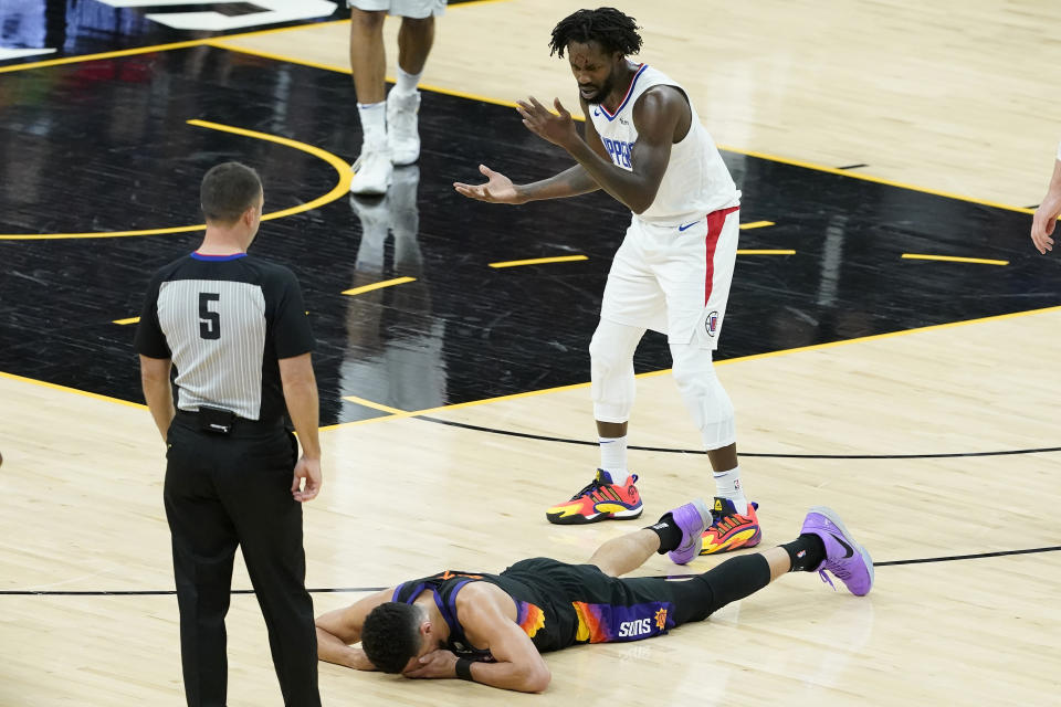 Los Angeles Clippers guard Patrick Beverley, top, reacts after being called for a foul on Phoenix Suns guard Devin Booker, bottom, during the second half of Game 2 of the NBA basketball Western Conference Finals, Tuesday, June 22, 2021, in Phoenix. (AP Photo/Matt York)