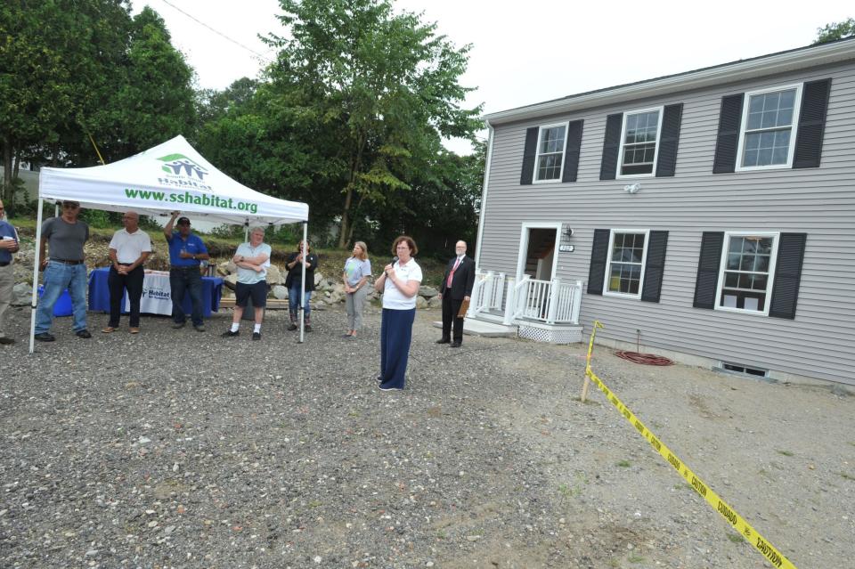 South Shore Habitat for Humanity Executive Director Beth Lyons welcomes guests and families during the dedication of two new Habitat for Humanity homes in Hingham.