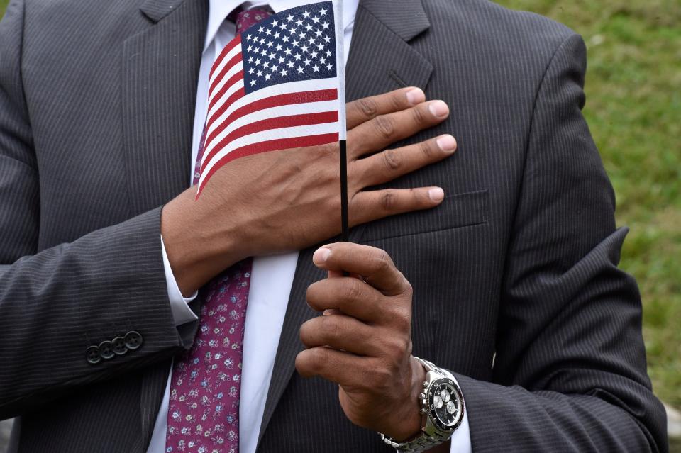 Ramiro Game Florez, of Colombia, places his hand on his heart as they singing of God Bless America. The Paterson Great Falls National Historical Park was the backdrop to a Naturalization Ceremony where 35 individuals from 12 countries declare their oath of allegiance to become citizens of the United States of America on Oct. 6, 2021.