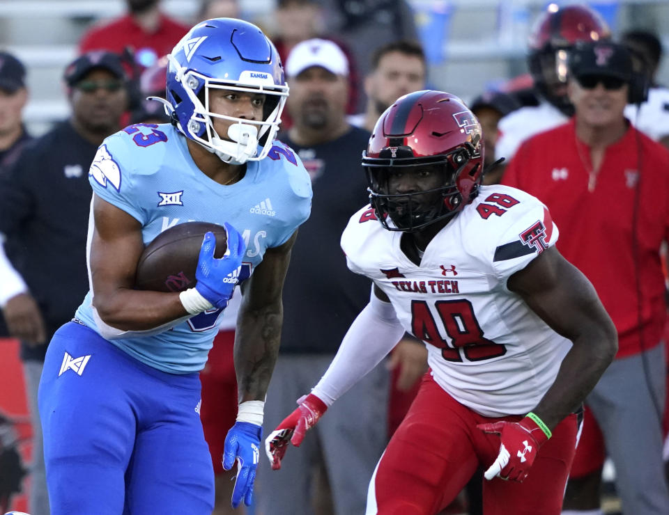 Kansas running back Amauri Pesek-Hickson (23) rushes against Texas Tech linebacker Derrick Lewis II (48) in the fourth quarter of an NCAA college football game Saturday, Oct. 16, 2021, in Lawrence, Kan. (AP Photo/Ed Zurga)