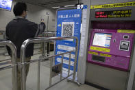 In this April 1, 2020 photo, a passenger scans a QR code to get his green pass at a subway station in Wuhan in central China's Hubei province. Life in China post-coronavirus outbreak is ruled by a green symbol on a smartphone screen. Green signifies the "health code" that says the user is symptom-free. It is required to board a subway, check into a hotel or enter Wuhan, the city where the global pandemic began. (AP Photo/Ng Han Guan)