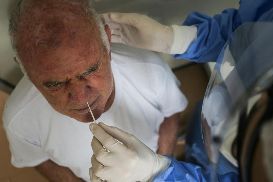 A health worker collects a swab sample from a man to test for the coronavirus disease (COVID-19), after cases of the Omicron variant were detected in Porto Alegre, Brazil, January 20, 2022. REUTERS/Diego Vara