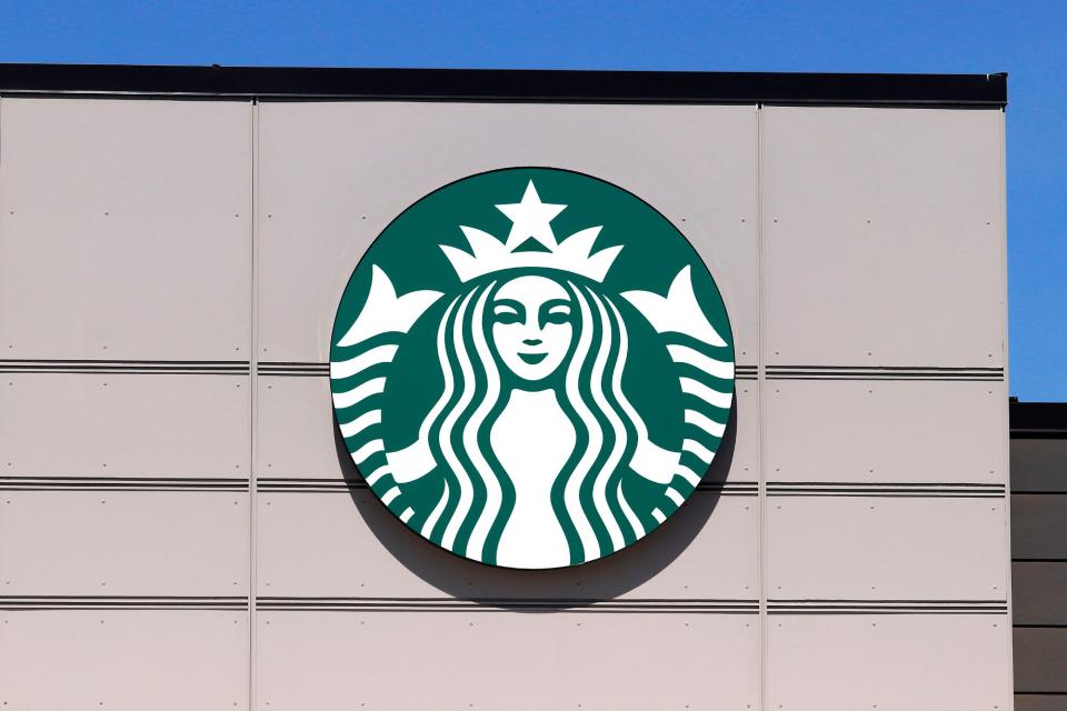 Starbucks coffee business logo on outside wall of one of their stores.