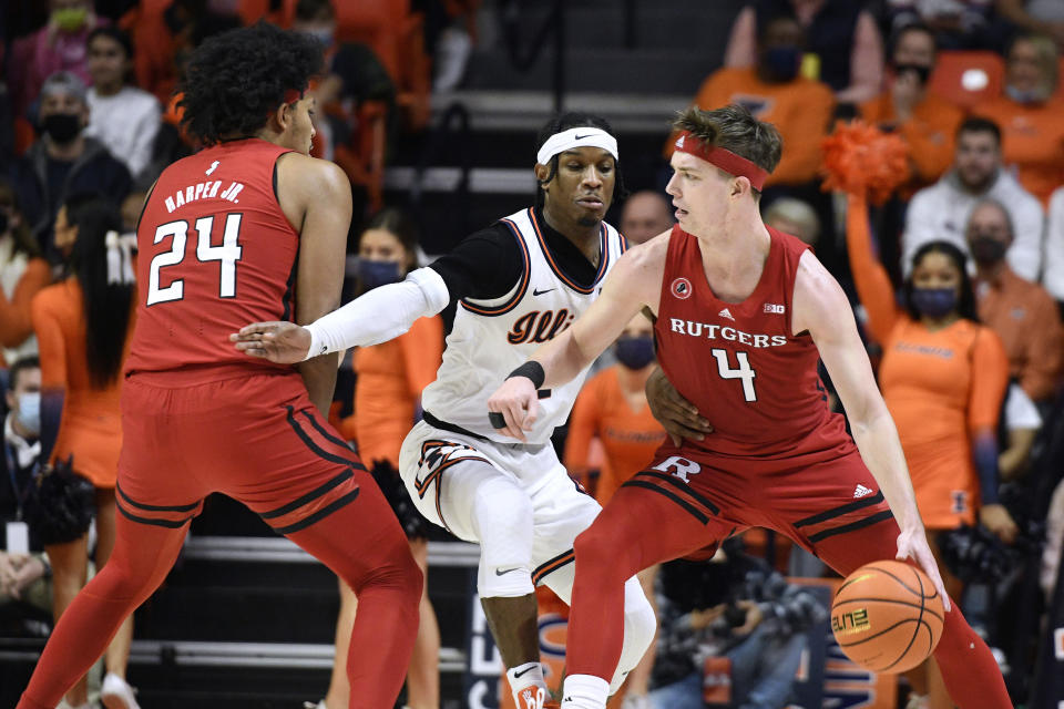 Rutgers' Paul Mulcahy (4) dribbles the ball as Ron Harper Jr. (24) sets a screen on Illinois' Trent Frazier during the first half of an NCAA college basketball game Friday, Dec. 3, 2021, in Champaign, Ill. (AP Photo/Michael Allio)