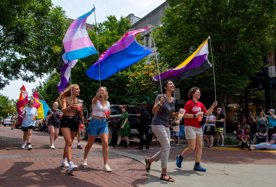 Participants walk down Main Street with flags during the 2023 River City Pride Parade and Festival in Evansville, Ind., Saturday, June 3, 2023.