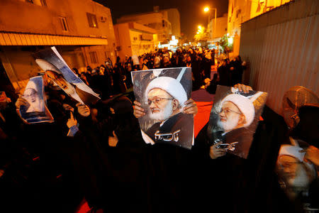 Protesters holding photos of Bahrain's leading Shi'ite cleric Isa Qassim shout religious slogans during a sit-in outside his home in the village of Diraz west of Manama, Bahrain July 27, 2016. Qassim went on trial on Wednesday on charges of collecting donations illegally and money laundering. REUTERS/Hamad I Mohammed