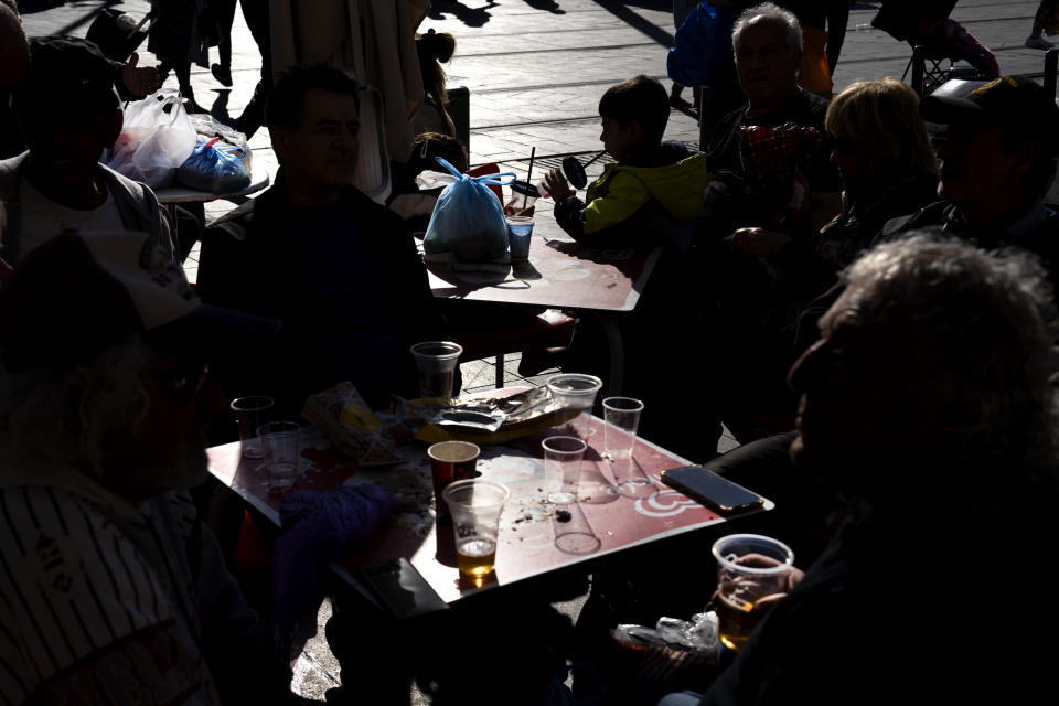 People drink in disposable plastic glass at Mahane Yehuda market in Jerusalem, Friday, Jan. 20, 2023. Israel's new government is in the process of repealing a new tax on single-use plastics. Ultra-Orthodox Jews, who have large families and use large quantities of disposable cups, plates and cutlery, say the tax unfairly targeted them. (AP Photo/Oded Balilty)