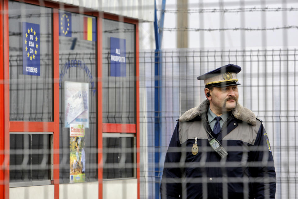 FILE - A Romanian border police officer stands guard at the railway border crossing point between Romania and Moldova in Ungheni, Romania, on Jan. 18, 2011. Bulgaria and Romania have received permission to join Europe’s passport- and visa-free Schengen Area starting in March, the governments of the two countries said. (AP Photo/Vadim Ghirda, File)