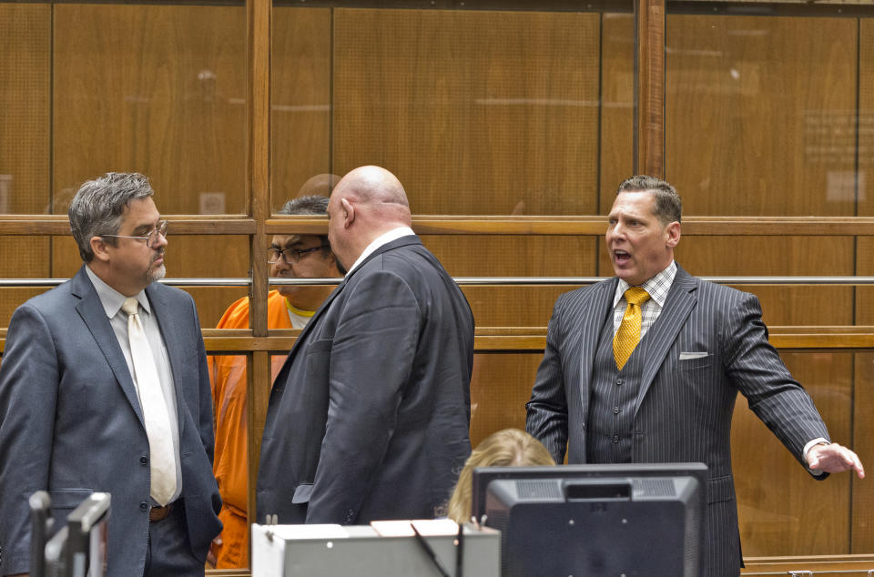 Naason Joaquin Garcia, the leader of Mexican megachurch La Luz del Mundo, behind bars, listens to a court interpreter as he appears with his attorneys, Allen Sawyer, far left, and Ken Rosenfeld, far right, in Los Angeles County Superior Court on Friday, June 21, 2019. García and his co-defendants were arrested earlier this month on suspicion of child rape, statutory rape, molestation, human trafficking, child pornography and extortion. The charges in the 26-count felony complaint detail allegations involving three girls and one woman between 2015 and 2018 in Los Angeles County. (AP Photo/Damian Dovarganes)