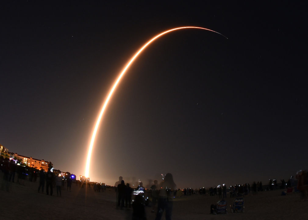 A long exposure of a light going across the sky at night showing a SpaceX rocket launching a Starlink mission.