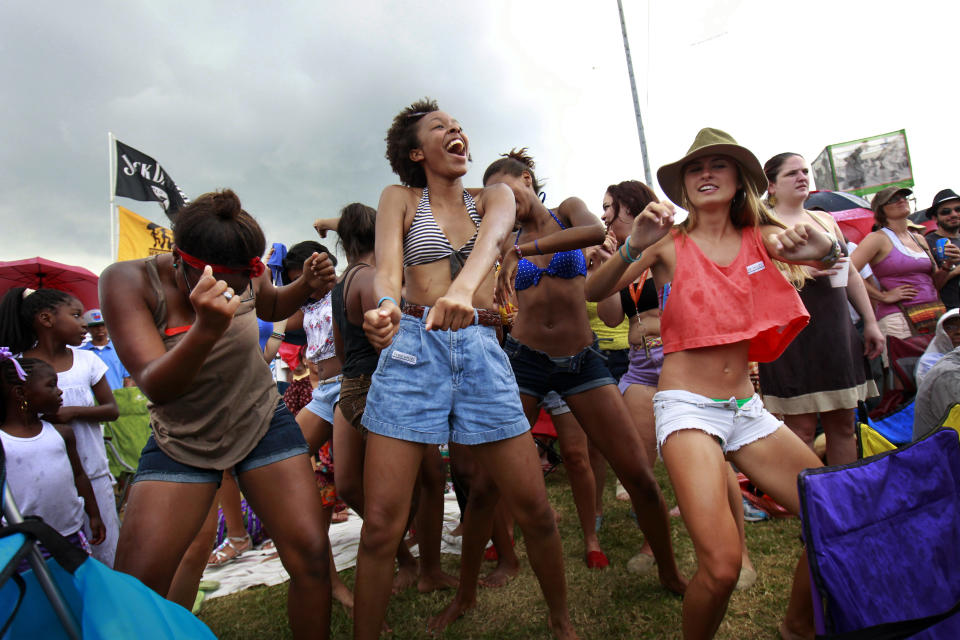 FILE - This May 6, 2012 file photo shows audience members dancing the 'Sissy Bounce' during the 'Bounce Shakedown' at the New Orleans Jazz and Heritage Festival in New Orleans. Despite heat, humidity, crowds and costs, music festivals are more popular than ever, attracting millions of fans, with 270 festivals of various types annually in the U.S. and more than 800 in 57 countries. (AP Photo/Gerald Herbert, file)