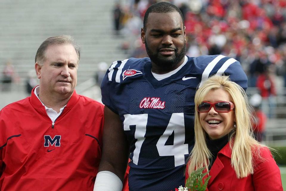 <p>Matthew Sharpe/Getty</p> From left: Sean Tuohy, Michael Oher, and Leigh Ann Tuohy