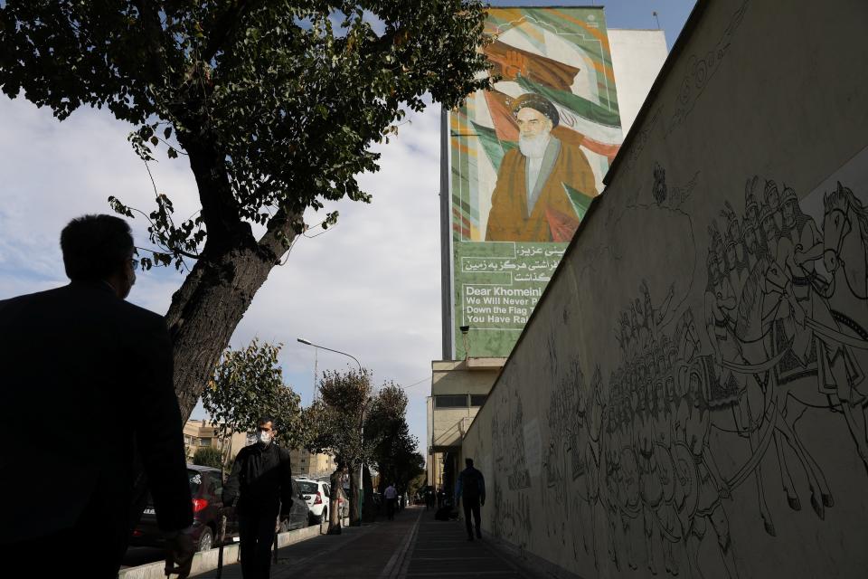 People walk on a pavement as a banner depicting Iran’s late leader Ayatollah Ruhollah Khomeini. Majid Asgaripour/WANA (West Asia News Agency) via REUTERS ATTENTION EDITORSVia REUTERS