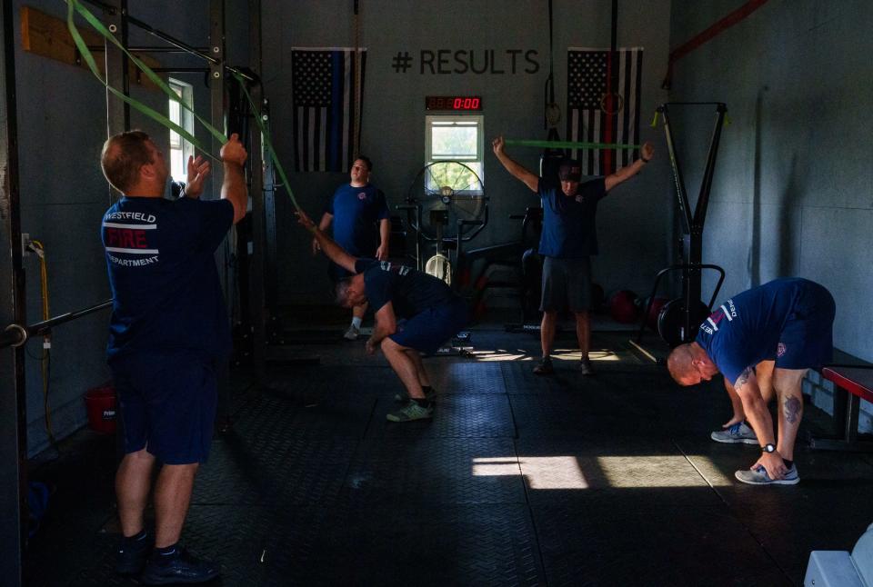 Westfield firefighters stretch to loosen up Thursday, July 21, 2022, before a workout at Westfield Fire Station 81. 