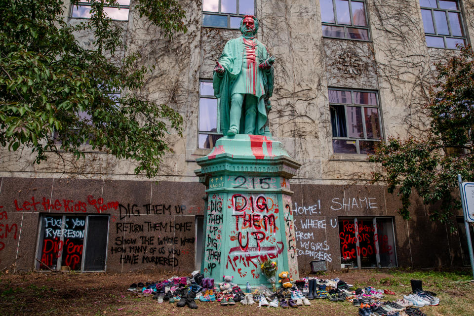 <p>Shoes were laid around the statue of Egerton Ryerson at Ryerson University as a memorial following the discovery of 215 bodies of students from residential schools in Kamloops, British Columbia. (Photo by Shawn Goldberg/SOPA Images/LightRocket via Getty Images)</p> 