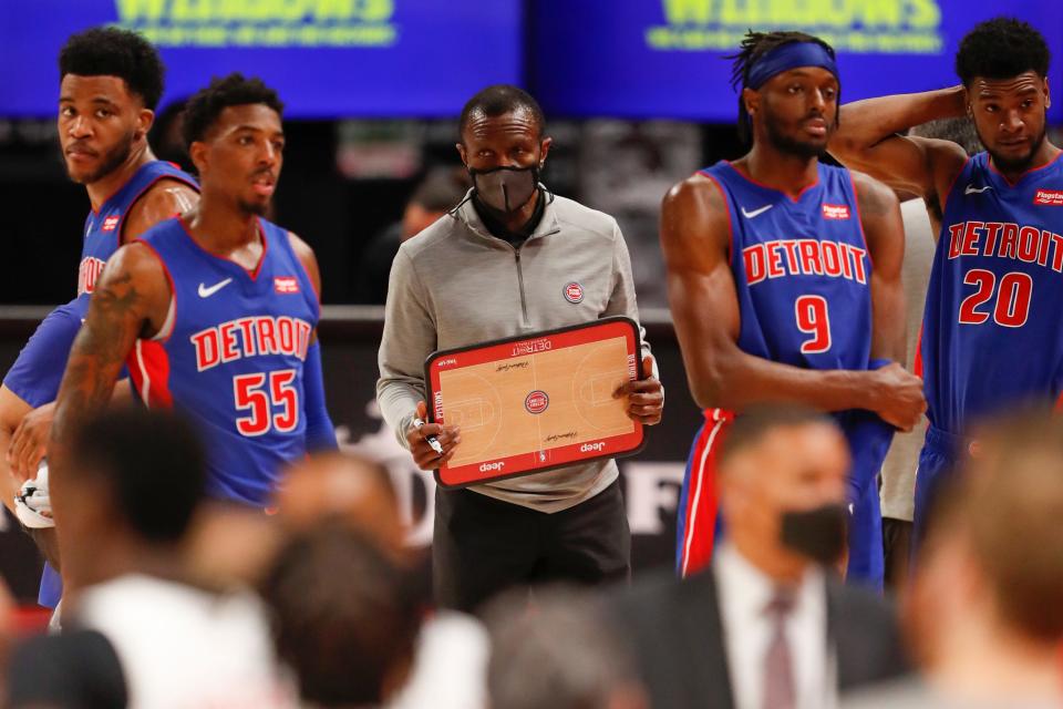 Detroit Pistons forward Saddiq Bey guard Delon Wright (55), head coach Dwane Casey (middle) and forward Jerami Grant (9) stand on the court during a timeout March 17, 2021, against the Toronto Raptors at Little Caesars Arena.