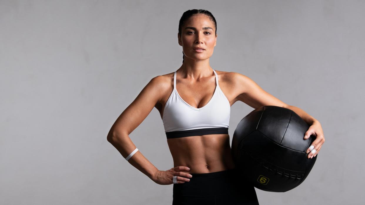  a photo of a woman with abs holding a medicine ball  