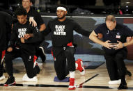 Portland Trail Blazers' Carmelo Anthony, center, the kneels with teammates and coaches during the national anthem before an NBA basketball game against the Memphis Grizzlies, Friday, July 31, 2020, in Lake Buena Vista, Fla. (Mike Ehrmann/Pool Photo via AP)