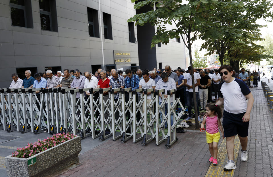 People perform Friday prayers at an open air mosque in Ankara, Turkey, Friday, Aug. 17, 2018. Turkey and the United States exchanged new threats of sanctions Friday, keeping alive a diplomatic and financial crisis.(AP Photo/Burhan Ozbilici)