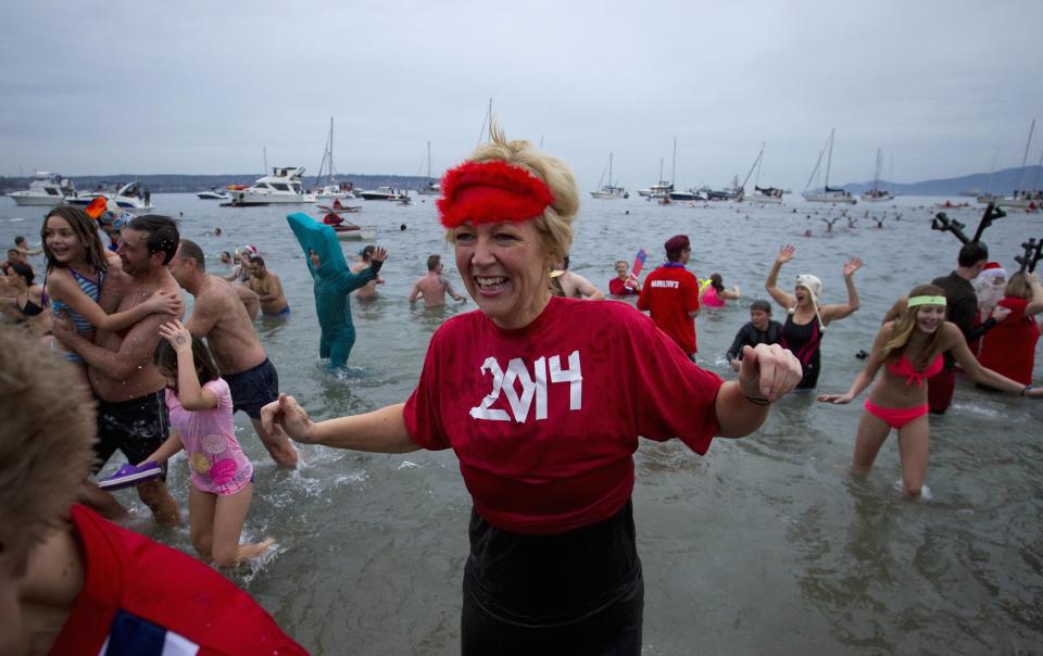 Participants run into English Bay during the 94th annual New Year's Day Polar Bear Swim in Vancouver