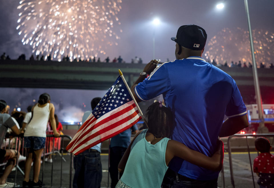 <p>Deon Stewart and his daughter Semiyah, of New York, join other spectators as they watch a fireworks display on the east side of Manhattan, part of Independence Day festivities Wednesday, July 4, 2018, in New York. (Photo: Craig Ruttle/AP) </p>