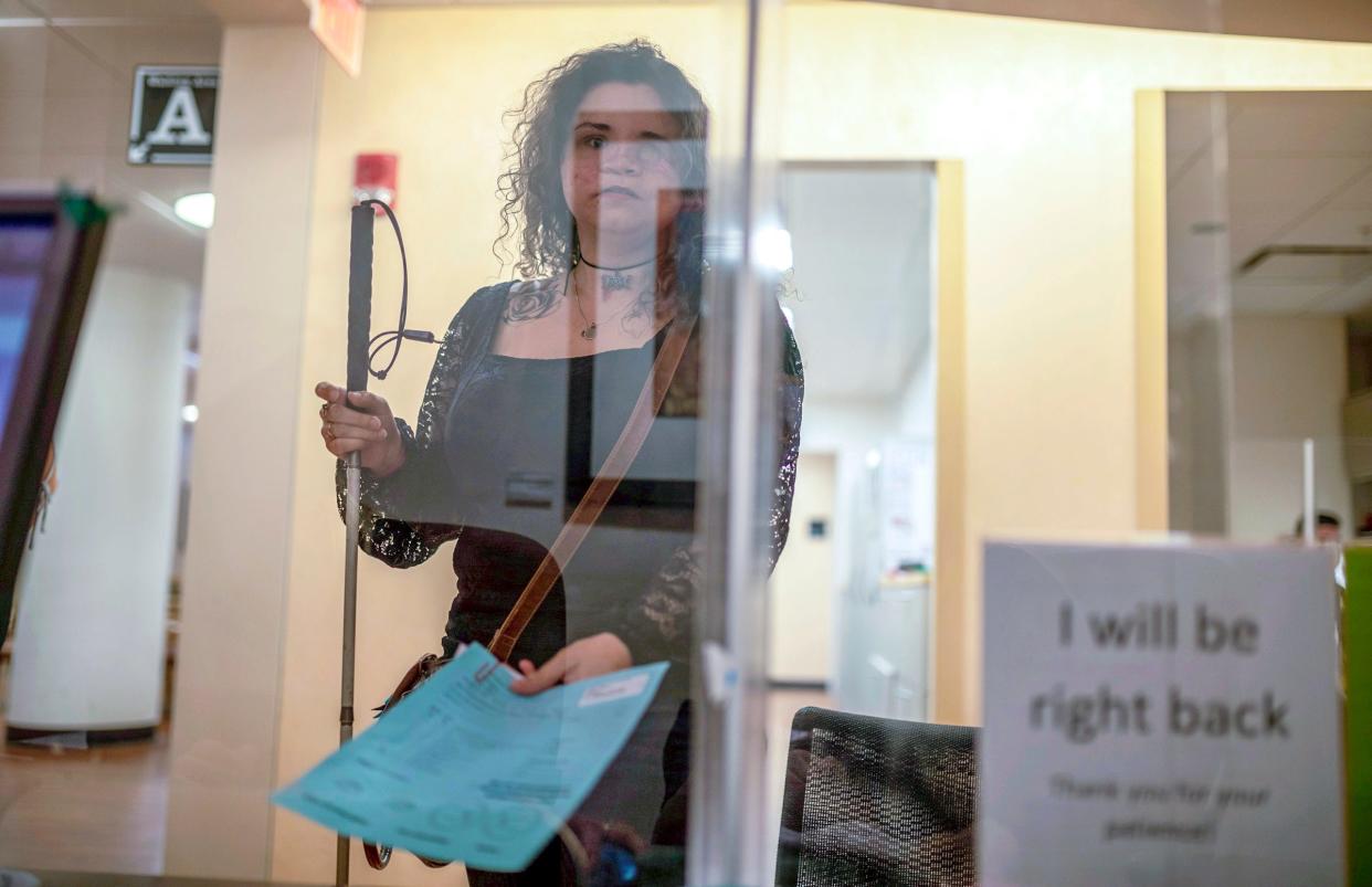 Amedy Dewey holds a form as she stands inside the University of Michigan W.K. Kellogg Eye Center during her eye care appointment in Ann Arbor on Thursday, June 15, 2023.