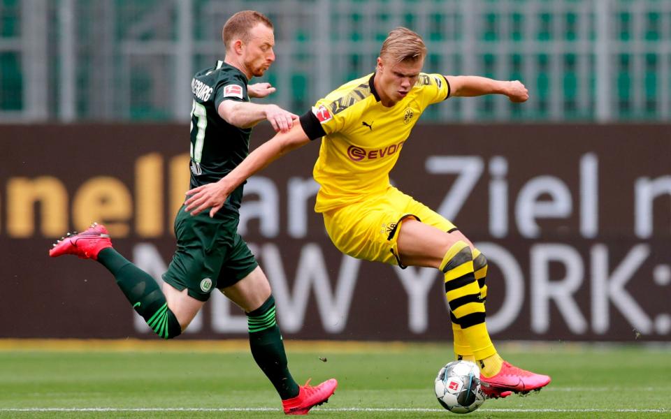 Dortmund's Norwegian forward Erling Braut Haaland controls the ball next to Wolfsburg's German midfielder Maximilian Arnold (L) during the German first division Bundesliga football match Vfl Wolfsburg vs Borussia Dortmund in Wolfsburg, on May 23, 2020. (Photo by Michael Sohn / POOL / AFP) / DFL REGULATIONS PROHIBIT ANY USE OF PHOTOGRAPHS AS IMAGE SEQUENCES AND/OR QUASI-VIDEO -  MICHAEL SOHN/AFP