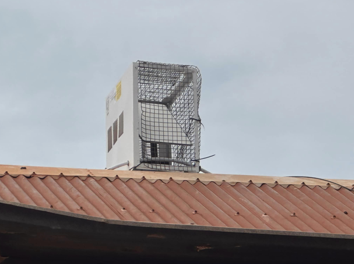 The old air conditioning vent 'protecting' a Starlink satellite dish on top of a home in the Northern Territory.