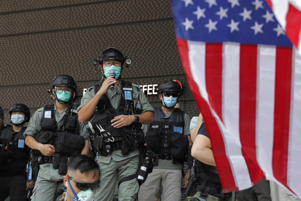 Image: Riot police stand guard in front of an American flag near the U.S. Consulate in Hong Kong, on the Fourth of July 2020. (Kin Cheung / AP)
