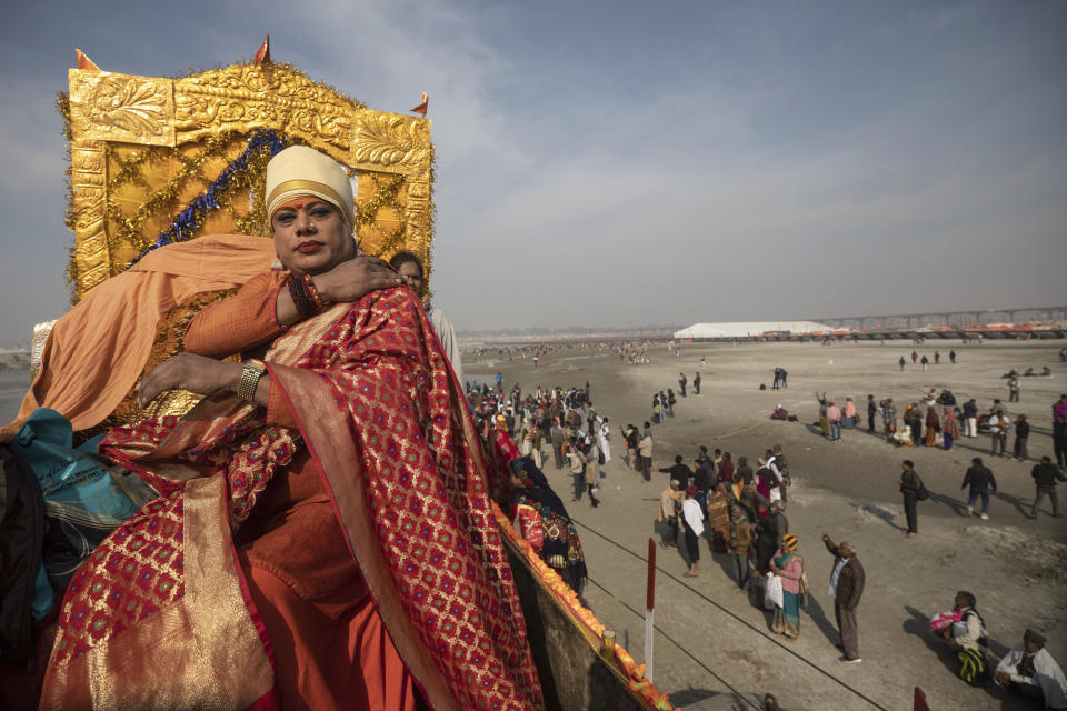 In this Jan. 15, 2019, photo, a member of the "Kinnar Akhara" monastic order sits on a carriage during a procession on auspicious Makar Sankranti day during the Kumbh Mela festival in Prayagraj, Uttar Pradesh state, India. Unlike other akharas, which are only open to Hindu men, Kinnar, founded in 2015, is open to all genders and religions. On the Kumbh’s first bathing day, transgender activist Laxmi Narayan Tripathi led a train of 21 tractor chariots from their tent camp to the bathing ghats with devotees following on foot as observers showered them with flower petals. (AP Photo/Bernat Armangue)