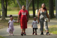 Tamika Davis, right, walks through MLK Park with three of her children, from left, Shanara, 3, Matthew, 11, and Lionel Jr., 2, in San Antonio, Thursday, May 30, 2024. As a cancer patient, she said a case manager set a book of available resources on her bedside table and did nothing else. Davis, a nursing professor, found the book confusing. (AP Photo/Eric Gay)