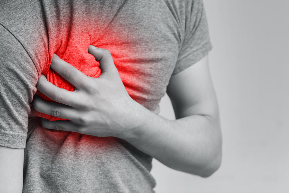 Acute pain in chest, man touching his inflamed breast, close-up