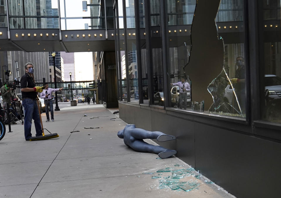 Tom Stellar, a pastor at Bethlehem Baptist Church, looks at broken windows while cleaning up damage outside Nordstrom Rack in Minneapolis on Thursday, Aug. 27, 2020. An emergency curfew expired and downtown Minneapolis was calm Thursday morning after a night of unrest that broke out following what authorities said was misinformation about the suicide of a Black homicide suspect. (David Joles/Star Tribune via AP)