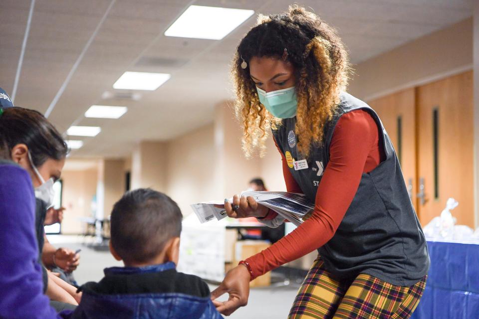 Tiphereth Hassan, a representative from the YMCA, handed out stickers to children and vaccinated adults during a booster shot clinic with the Mexican Consulate October 8, 2021. Vaccination efforts in Buncombe are ongoing in summer 2022.