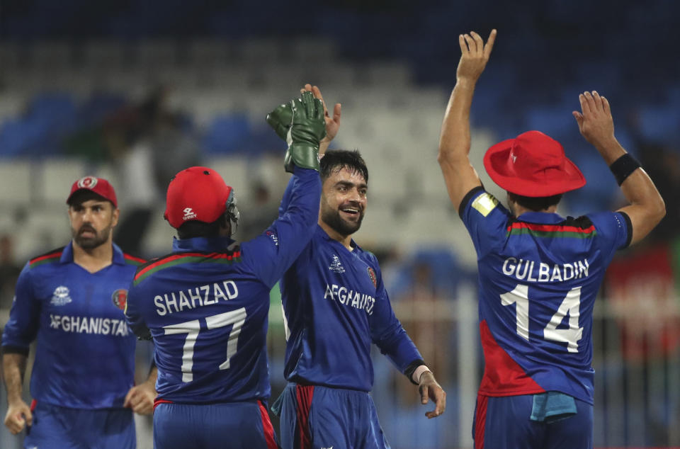 Afghanistan's Rashid Khan, second right, celebrates the dismissal of Scotland's Michael Leask during the Cricket Twenty20 World Cup match between Afghanistan and Scotland in Sharjah, UAE, Monday, Oct. 25, 2021. (AP Photo/Aijaz Rahi)