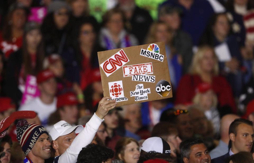 A Trump supporters holds up a fake news sign during a Trump rally.