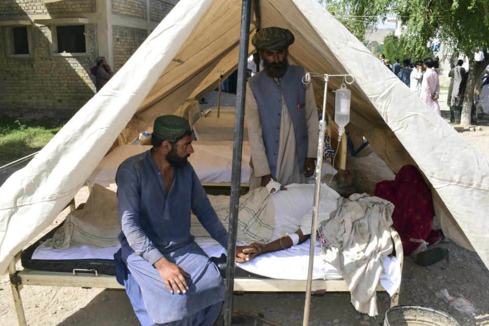 An injured men receives treatment in a tent set up at a local hospital following an earthquake in Harnai, about 100 kilometers (60 miles) east of Quetta, Pakistan, Thursday, Oct. 7, 2021. The powerful earthquake collapsed at least one coal mine and dozens of mud houses in southwest Pakistan early Thursday. (AP Photo/Arshad Butt)