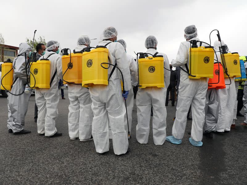 Volunteers prepare to spray disinfectant along a street to prevent the spread of the coronavirus disease (COVID-19) in Kabul