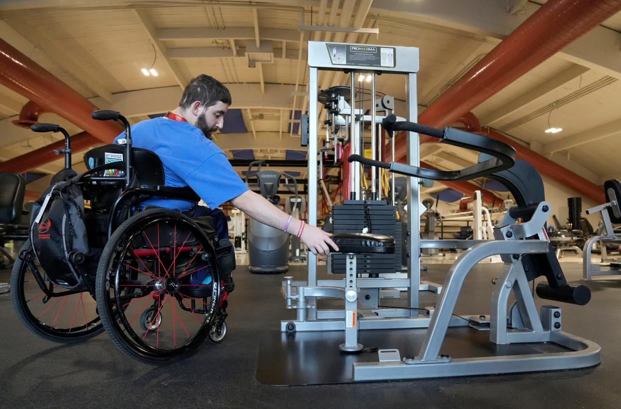 Max Damron, 24, swings a seat back into place after using a strength training machine at Columbus Parks and Recreation's Franklin Park Adventure Center, home to a fitness facility which meet the needs of individuals with disabilities. The equipment that Damron uses easily adapts to accommodate an individual who uses a wheelchair.
