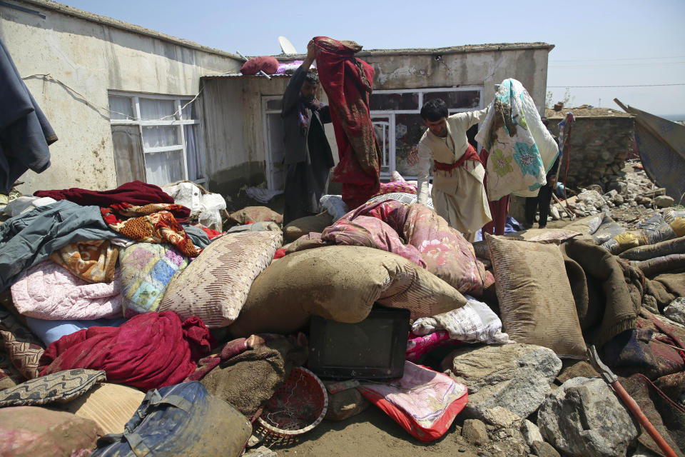 Afghans salvage belongings from their house that was damaged by flooding in the Parwan province, north of Kabul, Afghanistan, Thursday, Aug. 27, 2020. The death toll from heavy flooding in northern and eastern Afghanistan rose to at least 150 on Thursday, with scores more injured as rescue crews searched for survivors beneath the mud and rubble of collapsed houses, officials said. (AP Photo/Rahmat Gul)