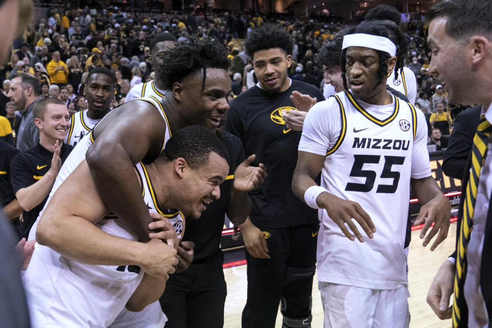 Missouri's Nick Honor, bottom left, his hugged by Kobe Brown as Sean East II watches after Honor's game-winning basket in overtime against Mississippi State in an NCAA college basketball game Tuesday, Feb. 21, 2023, in Columbia, Mo. (AP Photo/L.G. Patterson)