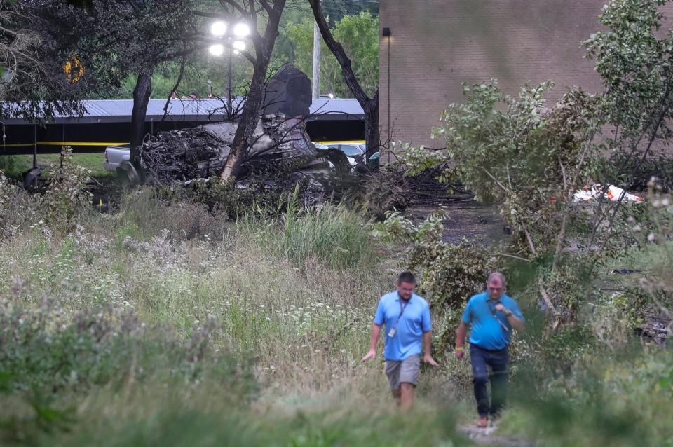 Officials investigate the site where a MiG-23 crashed during the Thunder Over Michigan air show near the Waverly on the Lake apartment complex in Van Buren Township on Sunday, Aug. 13, 2023.