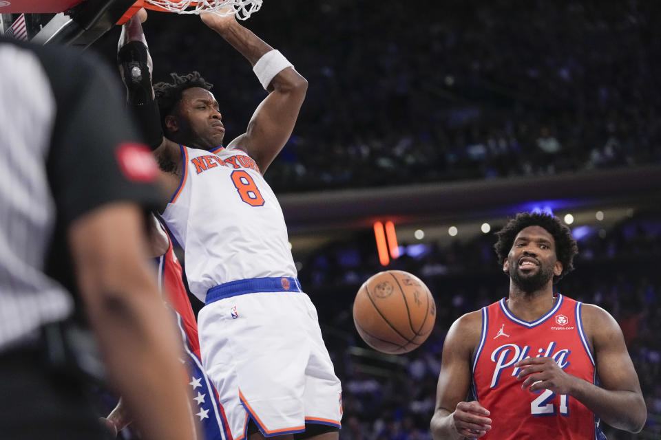 New York Knicks forward OG Anunoby (8) dunks past Philadelphia 76ers center Joel Embiid (21) during the second half in Game 1 of an NBA basketball first-round playoff series, Saturday, April 20, 2024, at Madison Square Garden in New York. (AP Photo/Mary Altaffer)
