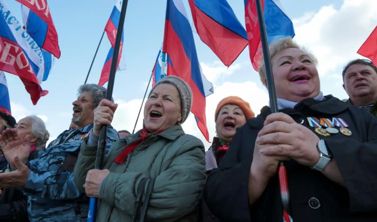 People wave the Russian national flag in Sevastopol on March 18, as they celebrate the third anniversary of the annexation of Crimea