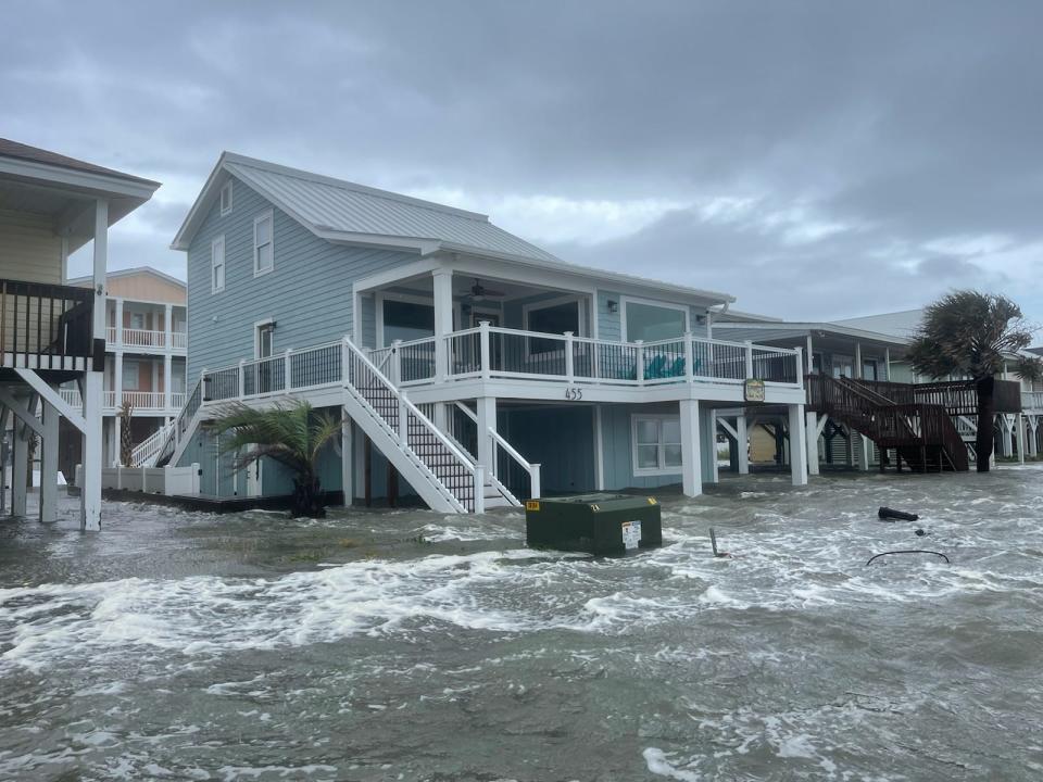 Homes and cars are partially submerged as the combination of a high tide and storm surge from Hurricane Isle left part of Ocean Isle Beach along E. Third Street flooded under multiple feet of water on Sept. 30, 2022.