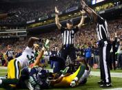 Officials signal after Seattle Seahawks wide receiver Golden Tate pulled in a last-second pass for a touchdown from quarterback Russell Wilson to defeat the Green Bay Packers 14-12 in an NFL football game, Monday, Sept. 24, 2012, in Seattle. The touchdown call stood after review. (AP Photo/seattlepi.com, Joshua Trujillo) MAGS OUT; NO SALES; SEATTLE TIMES OUT; TV OUT; MANDATORY CREDIT