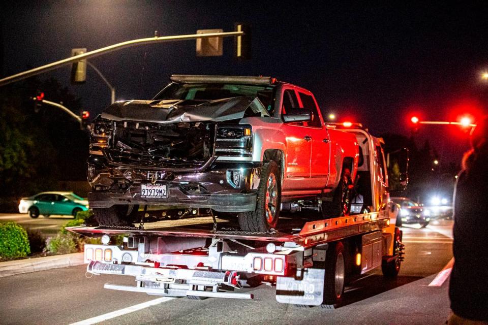 A tow truck drives a truck involved in a fatal hit-and-run out of an apartment complex on Friday, May 13, 2022. The driver is suspected of hitting and killing a 29-year-old woman, dragging her 8 miles through Fresno.